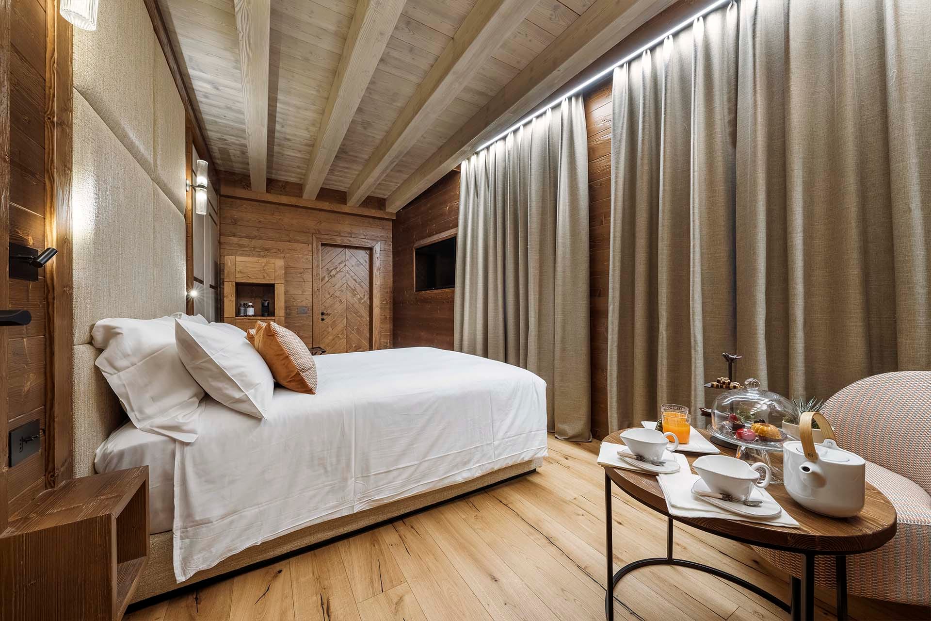 Dettaglio letto matrimoniale e tavolino con colazione Camera Family