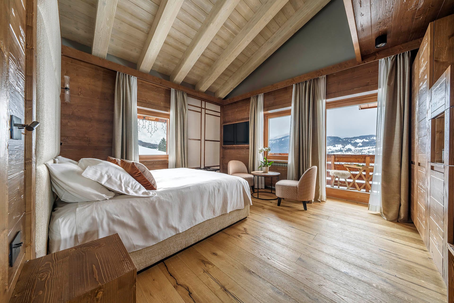 Camera Deluxe Doppia con letto matrimoniale ed ampie finestre con vista sulle montagne