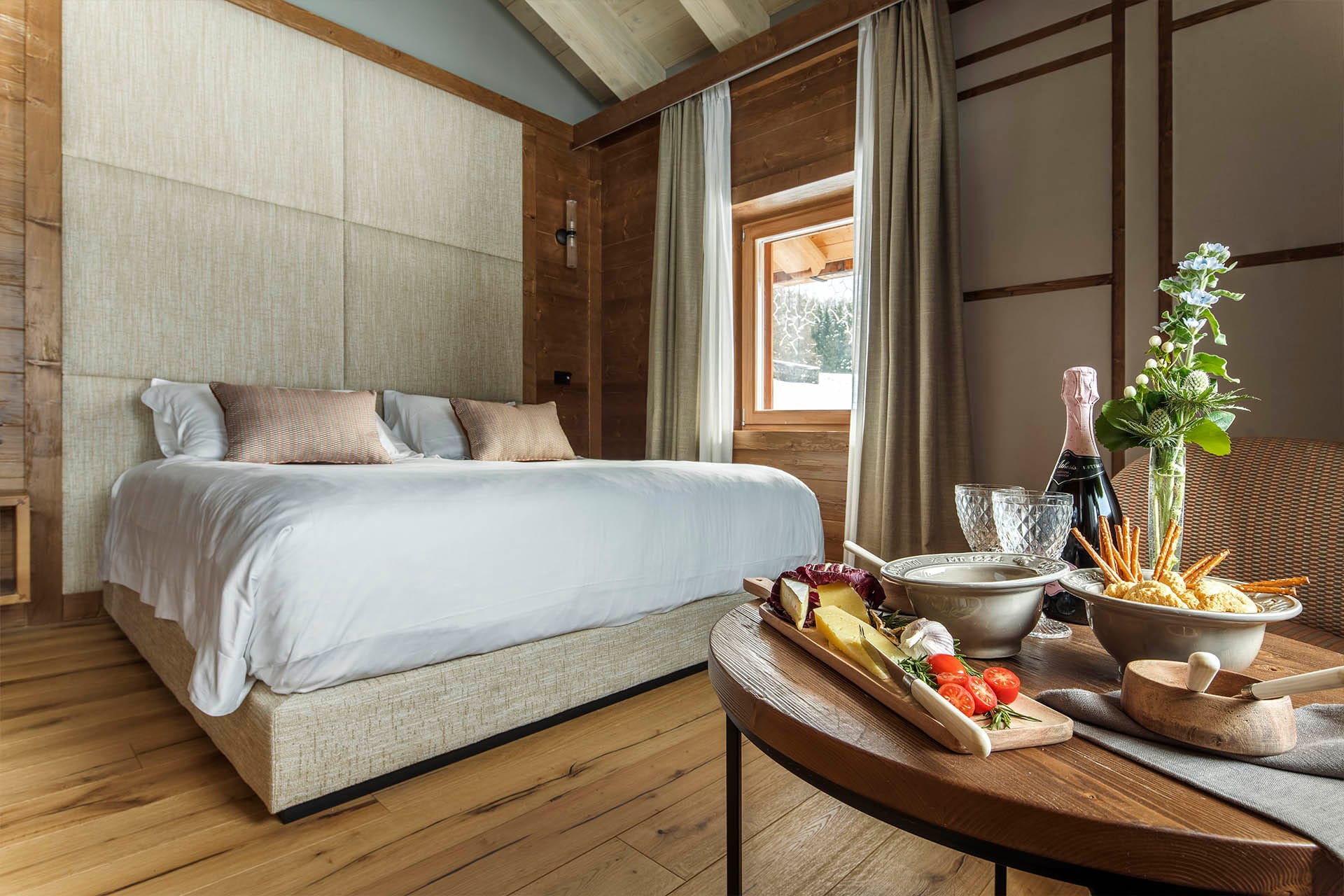 Camera Cosy con letto matrimoniale e piccolo buffet del servizio in camera con bottiglia di champagne